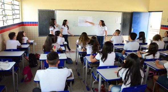 Concurso SEE PE: sentados em sala de aula, estudantes observam professor explicando conteúdo em lousa - SEE PE/Alyne Pinheiro