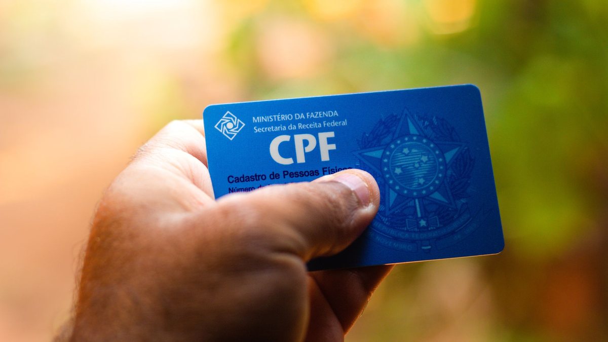 Um homem segura o cartão do Cadastro de Pessoas Físicas - Divulgação - CPF