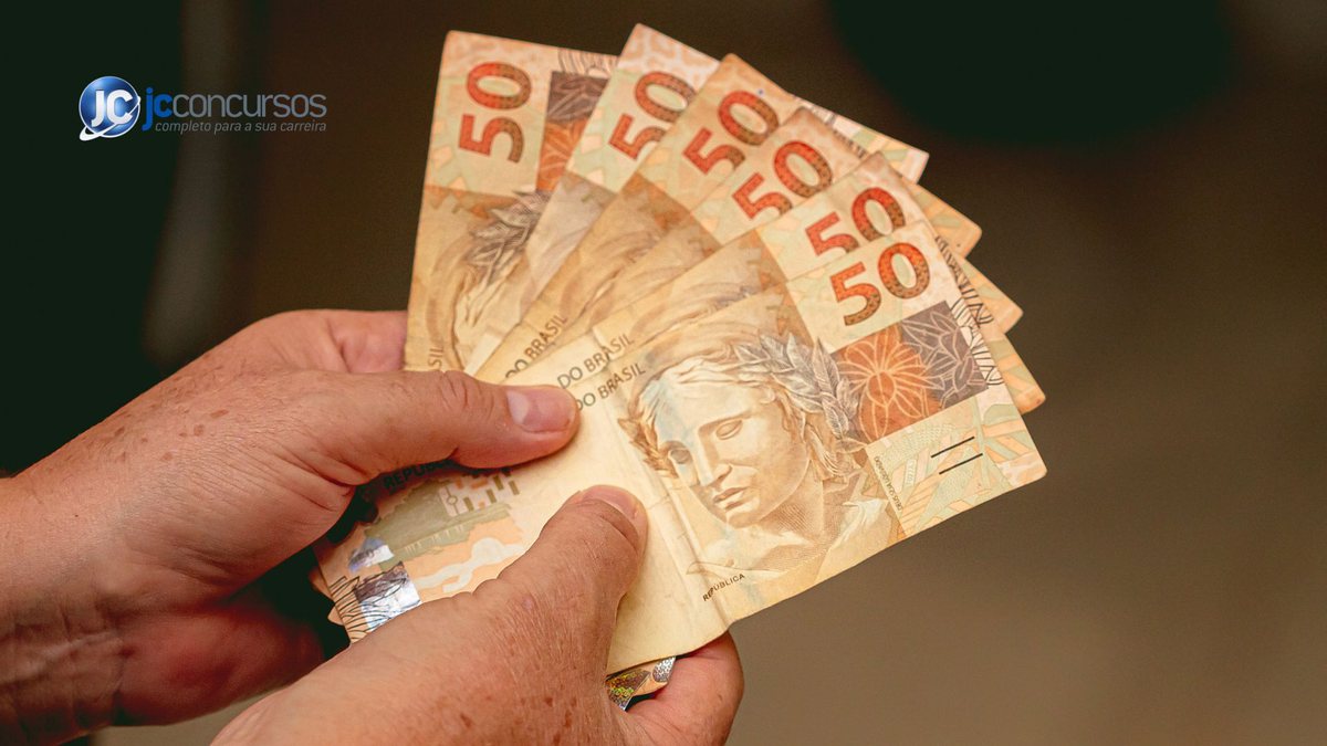 Um homem segura notas de dinheiro - Agência Brasil