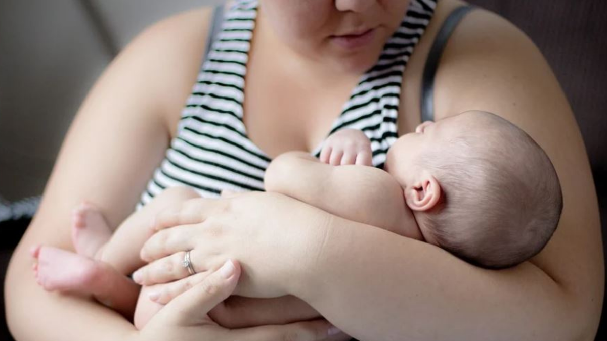 Benefício social: mãe segura bebê no colo