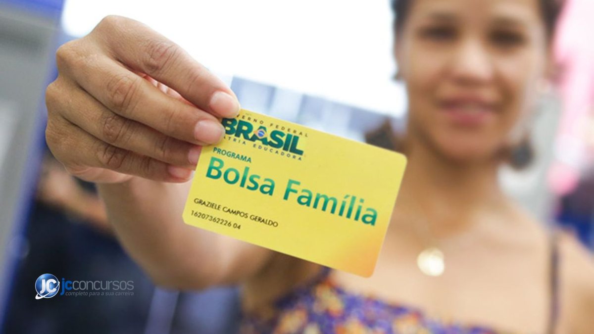 Uma mulher segura o cartão do programa de transferência de renda