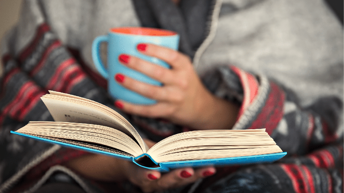Brasileiros lendo mais: mulher faz leitura de livro enquanto toma café