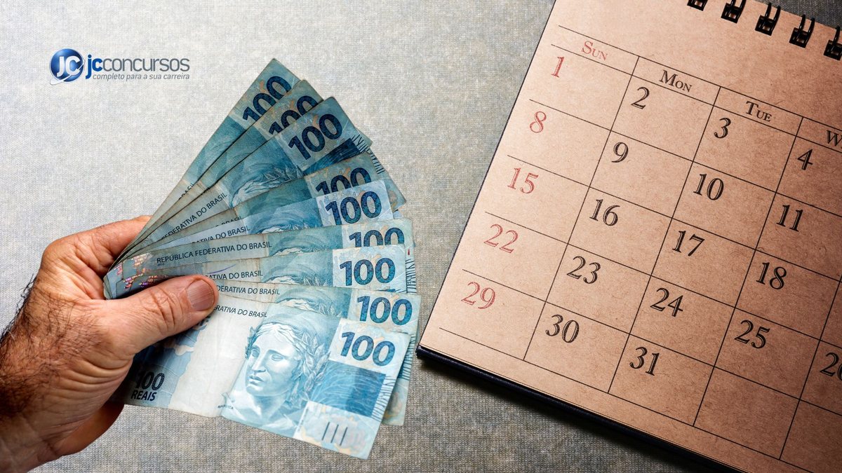 Um homem segura notas de dinheiro ao lado de um calendário