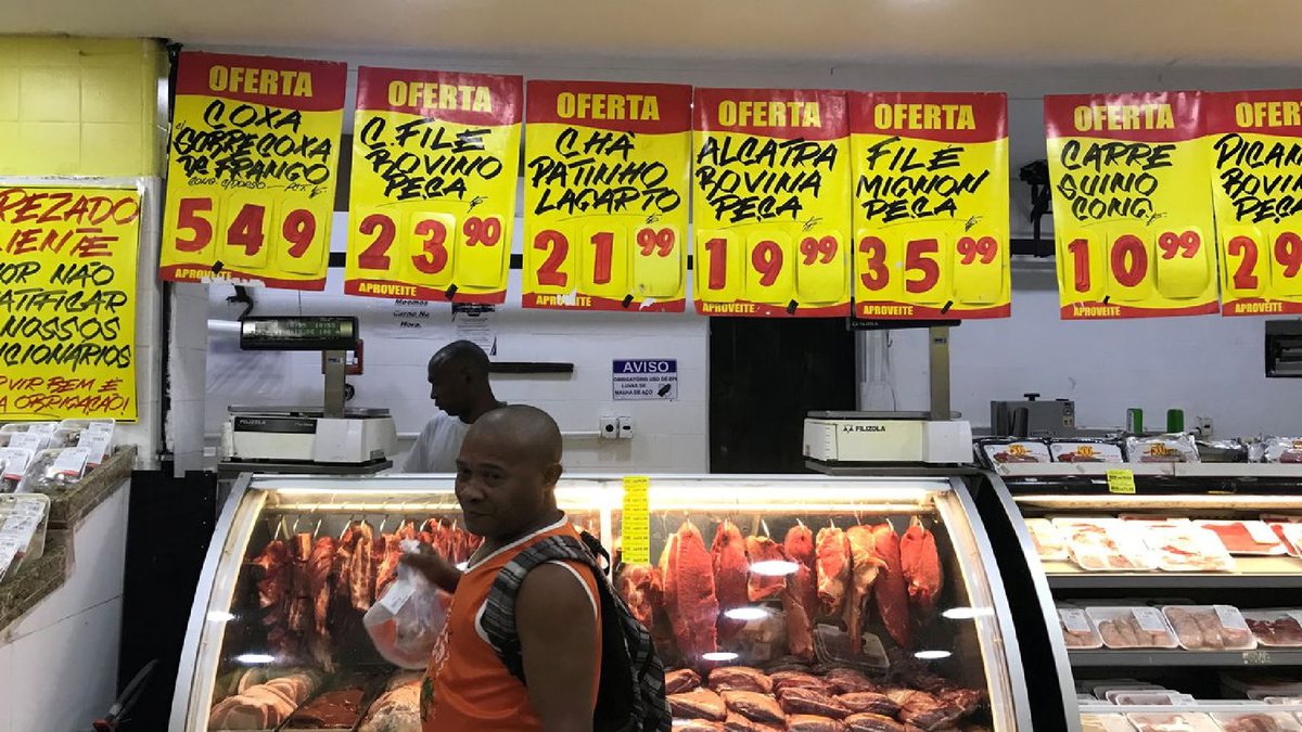 Um homem passa em uma vitrine de carnes no supermercado