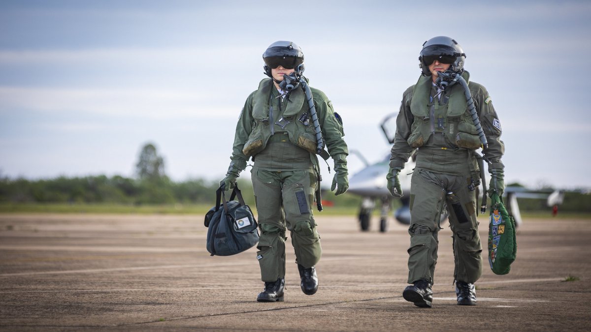 Concurso Aeronáutica: dois aviadores da Força Aérea Brasileira caminham em pista de decolagem