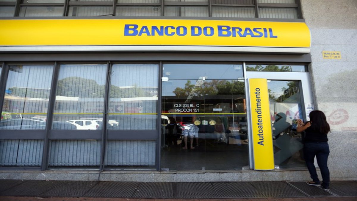 Concurso Banco do Brasil: mulher passa pela porta de agência do BB