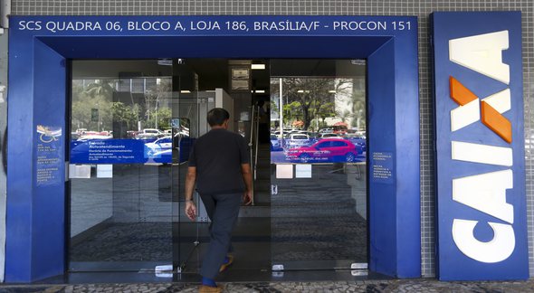 Concurso Caixa: homem passa pela porta de agência do banco - Marcelo Camargo/Agência Brasil