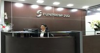 Concurso Funpresp-Jud: atendente sorrindo na recepção da fundação - Concurso Funpresp-Jud: atendente sorrindo na recepção da fundação