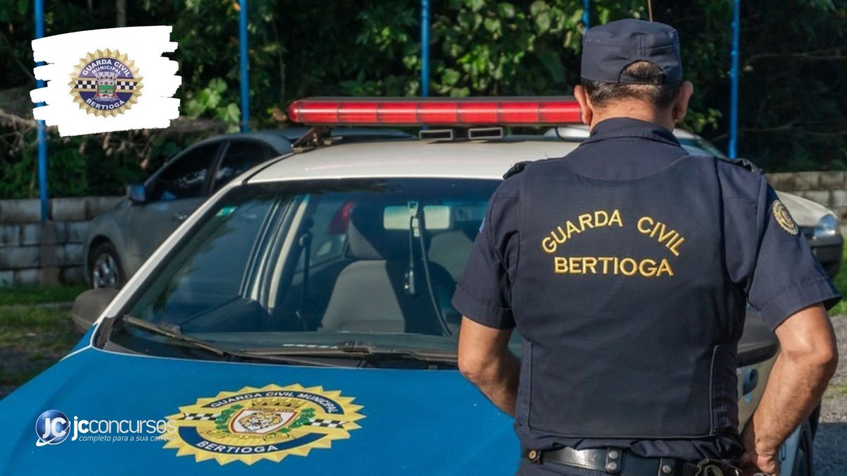 Concurso da Guarda Municipal de Bertioga: agente é visto de costas com uniforme da corporação ao lado de viatura