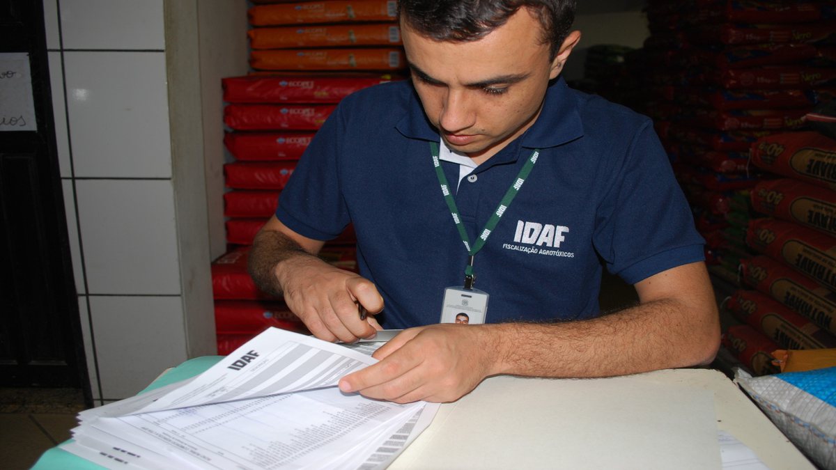 Concurso Idaf ES: fiscal analisa documentos durante operação em loja de agrotóxicos