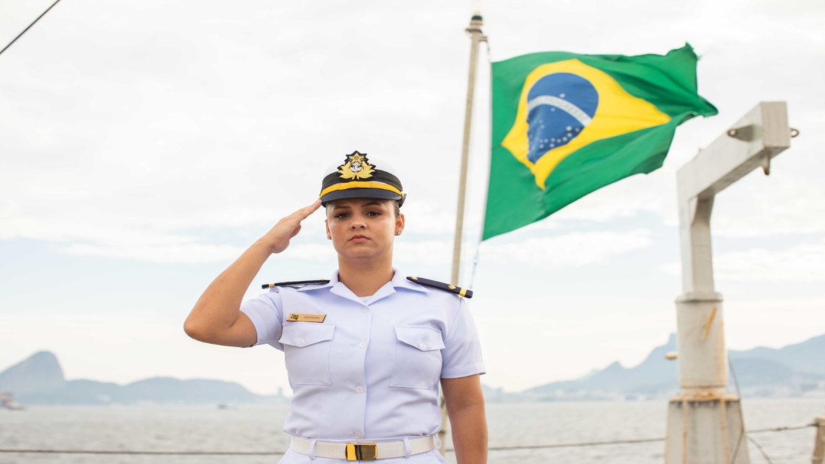 Concurso Marinha: com bandeira do Brasil ao fundo, militar presta continência