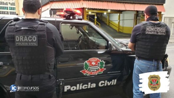 Concurso PC SP: policiais vistos de costas ao lado de viatura da corporação - Foto: Divulgação