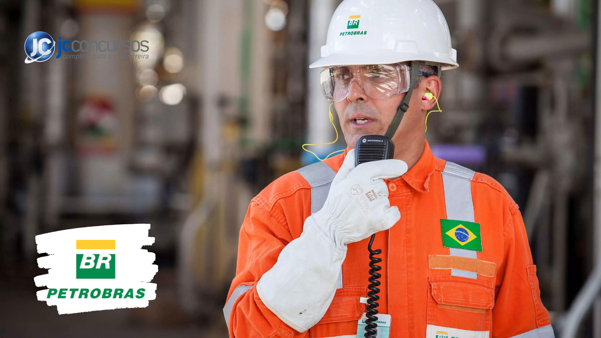 Funcionário da Petrobras com uniforme laranja, capacete branco, ócolus de proteção e luva branca segura rádio comunicador