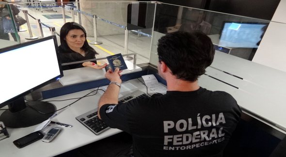 Concurso PF: agente da corporação entrega passaporte a mulher - Divulgação