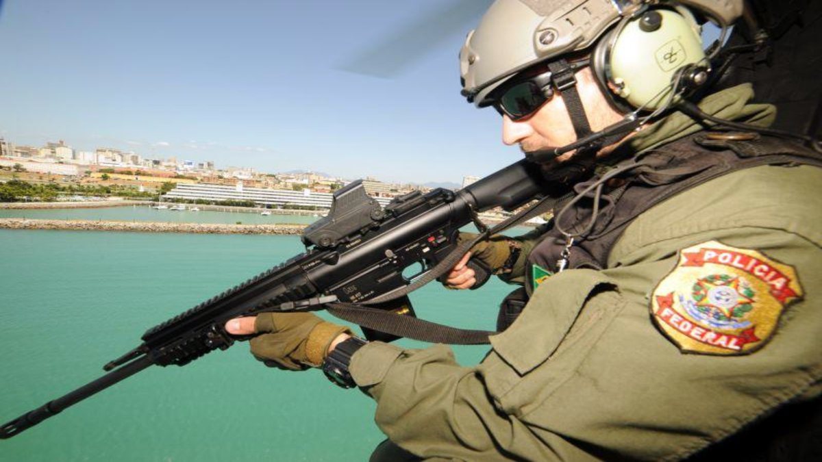 Concurso Polícia Federal: agente segura arma durante voo em helicóptero