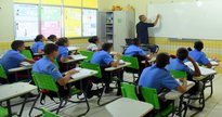 Concurso Seed RR: sentados em sala de aula, estudantes observam professor escrevendo em lousa - Divulgação