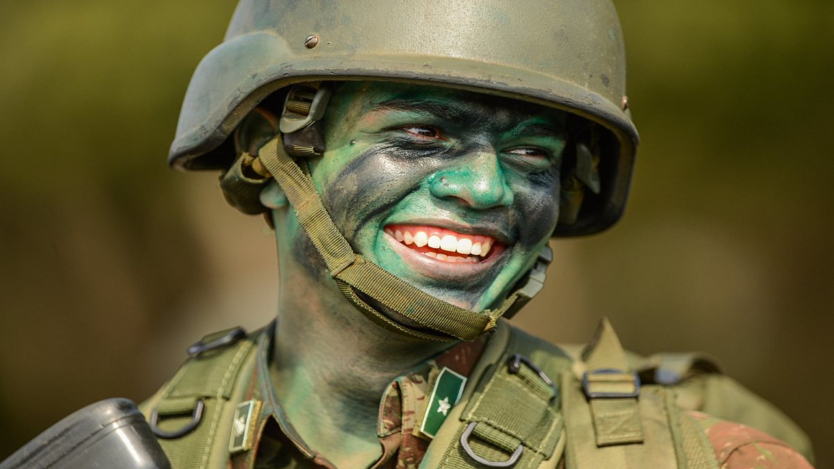 Concursos Forças Armadas: militar sorrindo com rosto pintado de verde e preto