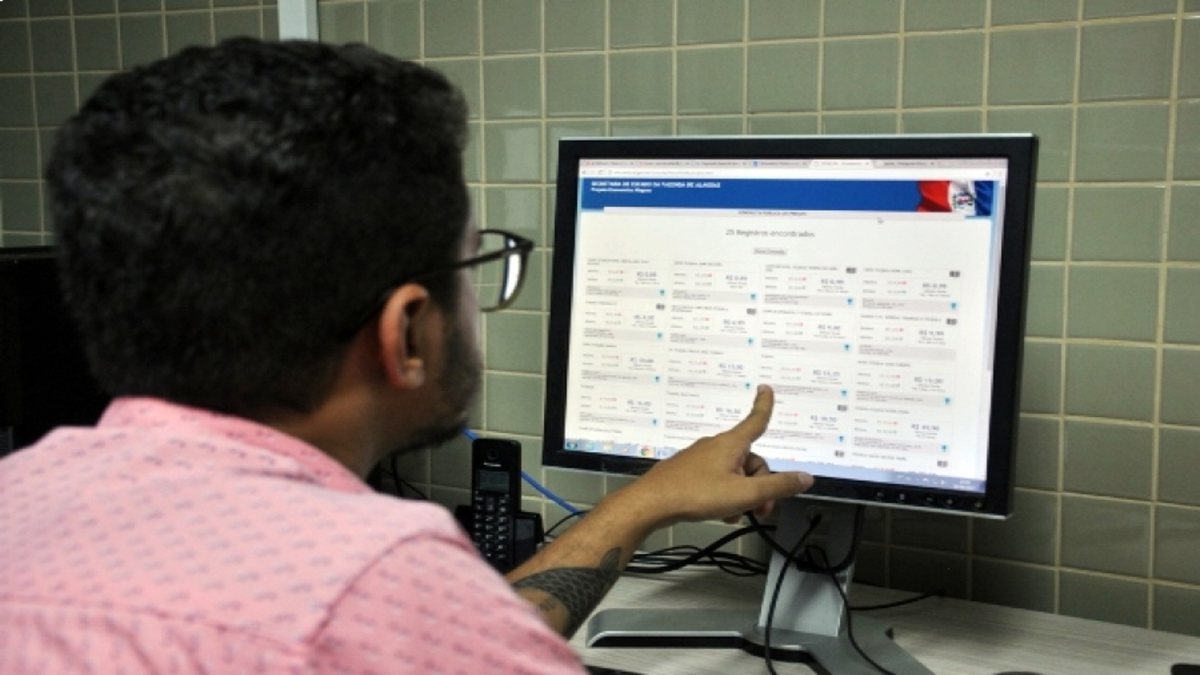 Concursos públicos: homem observa informações em tela de computador