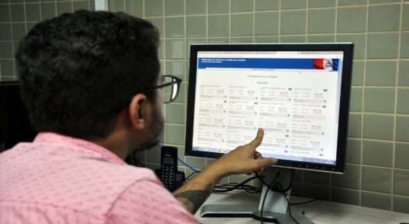 Concursos públicos: homem observa informações em tela de computador - Divulgação