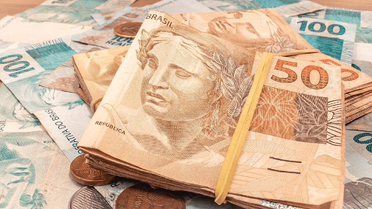 Dinheiro esquecido da Nota Fiscal Paulista: notas de cem e cinquenta reais espalhadas na mesa