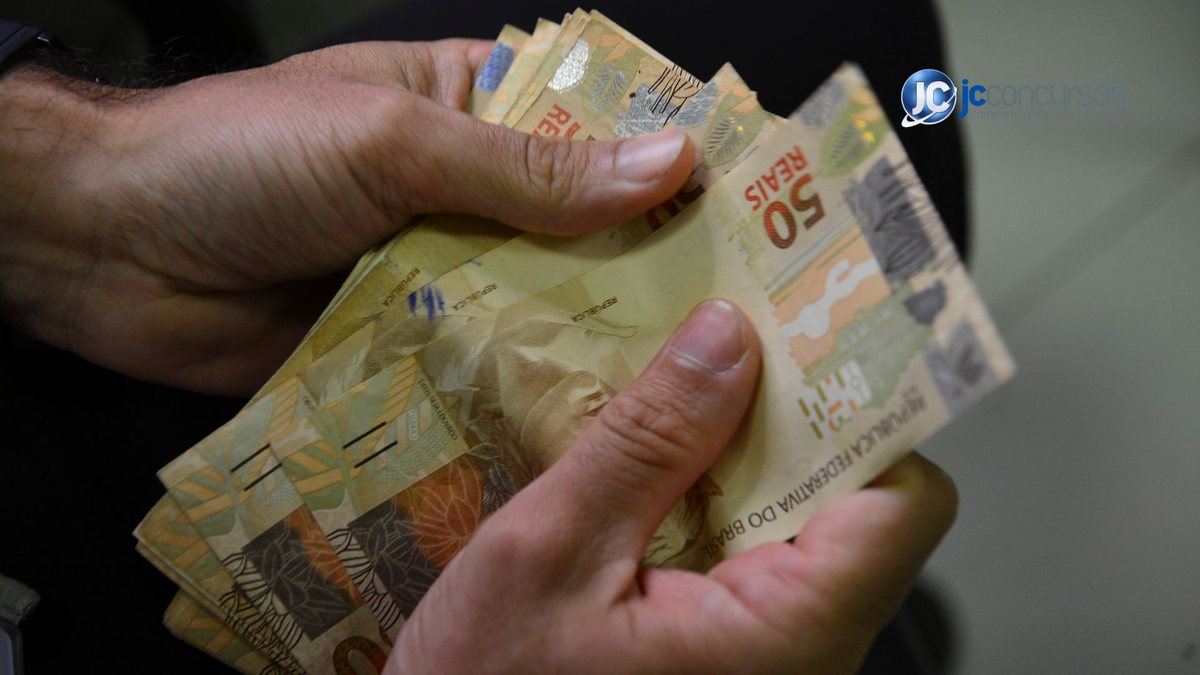 Um homem segura notas de dinheiro - Agência Brasil