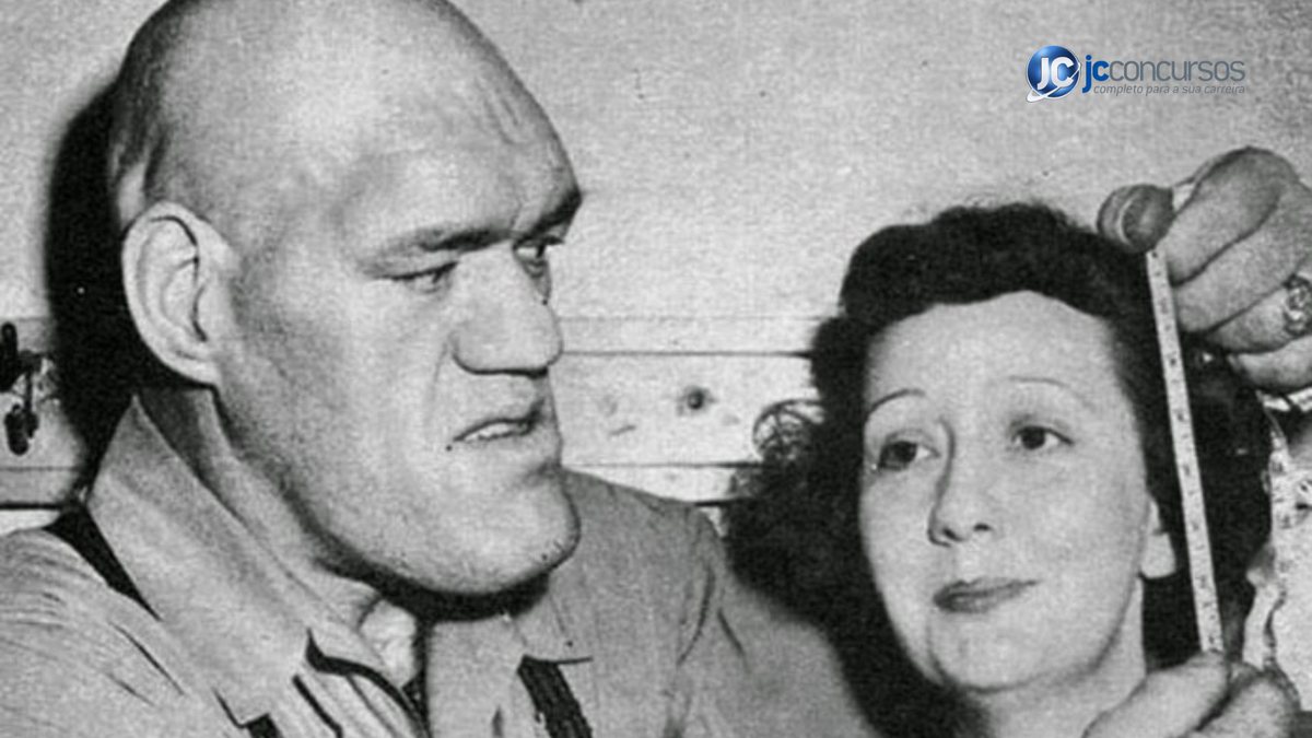 Maurice Tillet, francês conhecido pela condição rara de acromegalia, medindo a cabeça de uma mulher