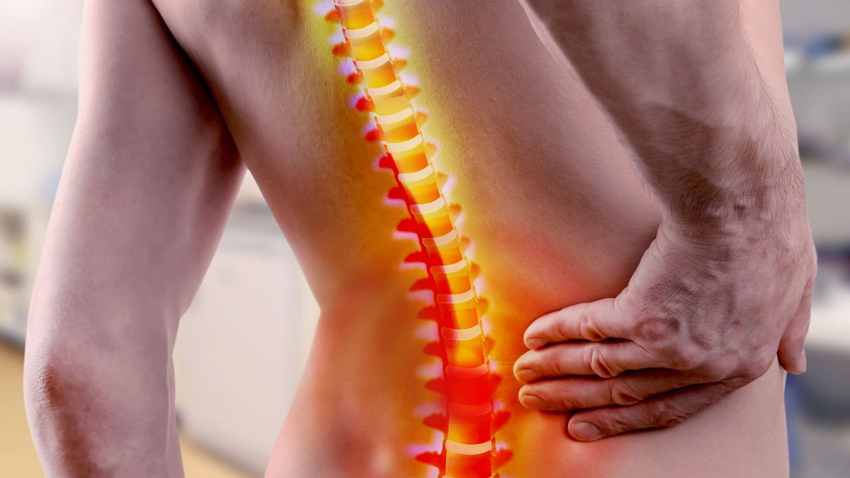 Benefícios do INSS: homem com dor na coluna coloca mão nas costas
