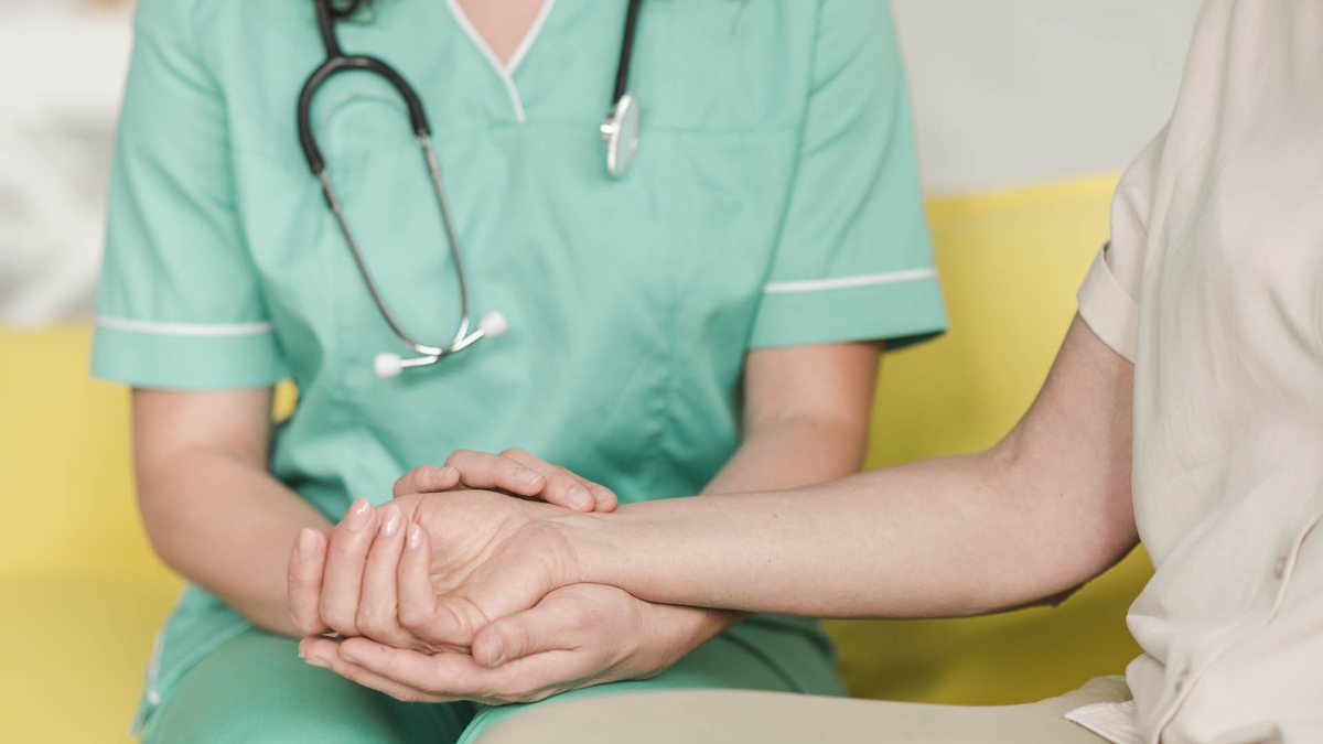 Piso salarial da enfermagem: enfermeira segura mão de paciente