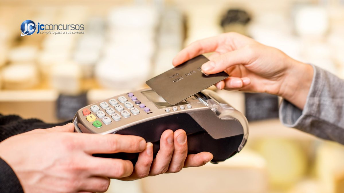 Pessoa passa cartão de crédito por aproximação em maquininha