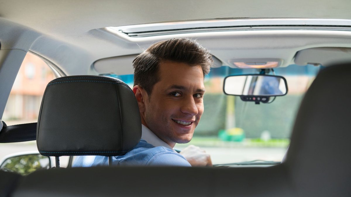 Golpe do Uber: motorista olha para o banco de trás do carro