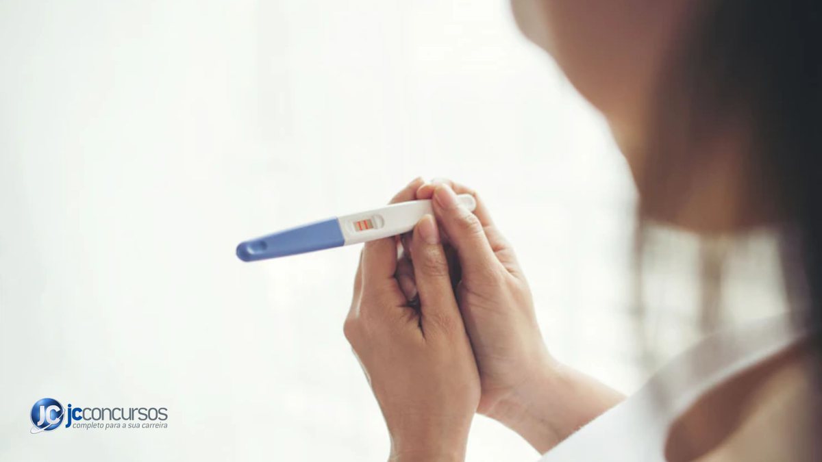 Mulher segurando um teste de gravidez de farmácia