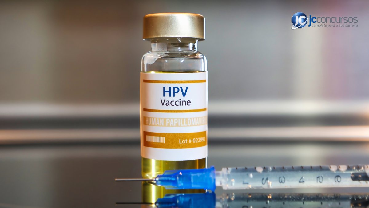 Pote com vacina contra o HPV e agulha na mesa