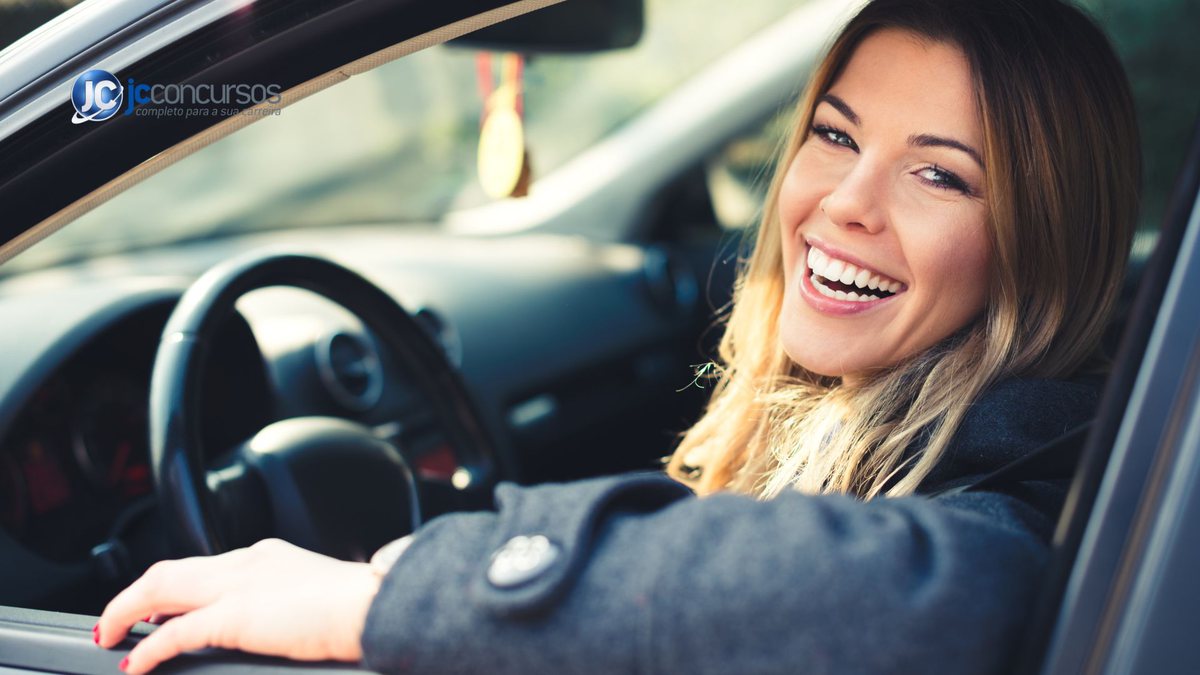 Motorista mulher sorri ao volante de carro