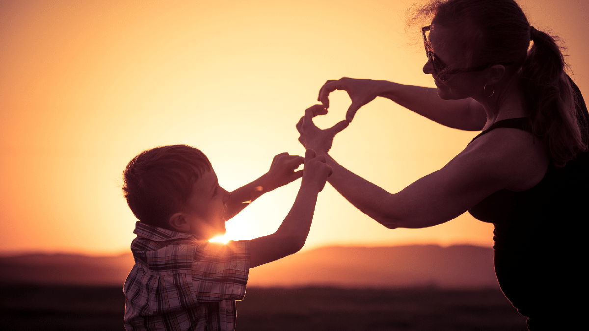 Licença maternidade: mãe e filho formam coração com as mãos