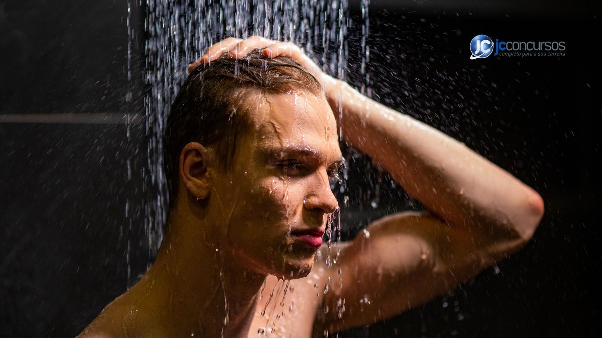 Um homem toma banho de chuveiro