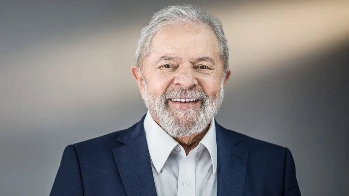 Eleições 2022: Lula, vestido com terno azul marinho, sorri