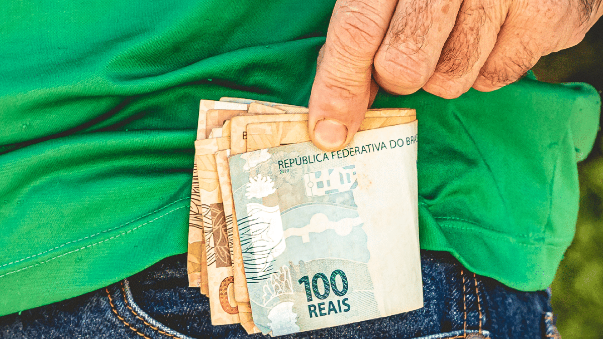 Dinheiro esquecido no banco: homem guarda notas de cinquenta e cem reais no bolso da calça