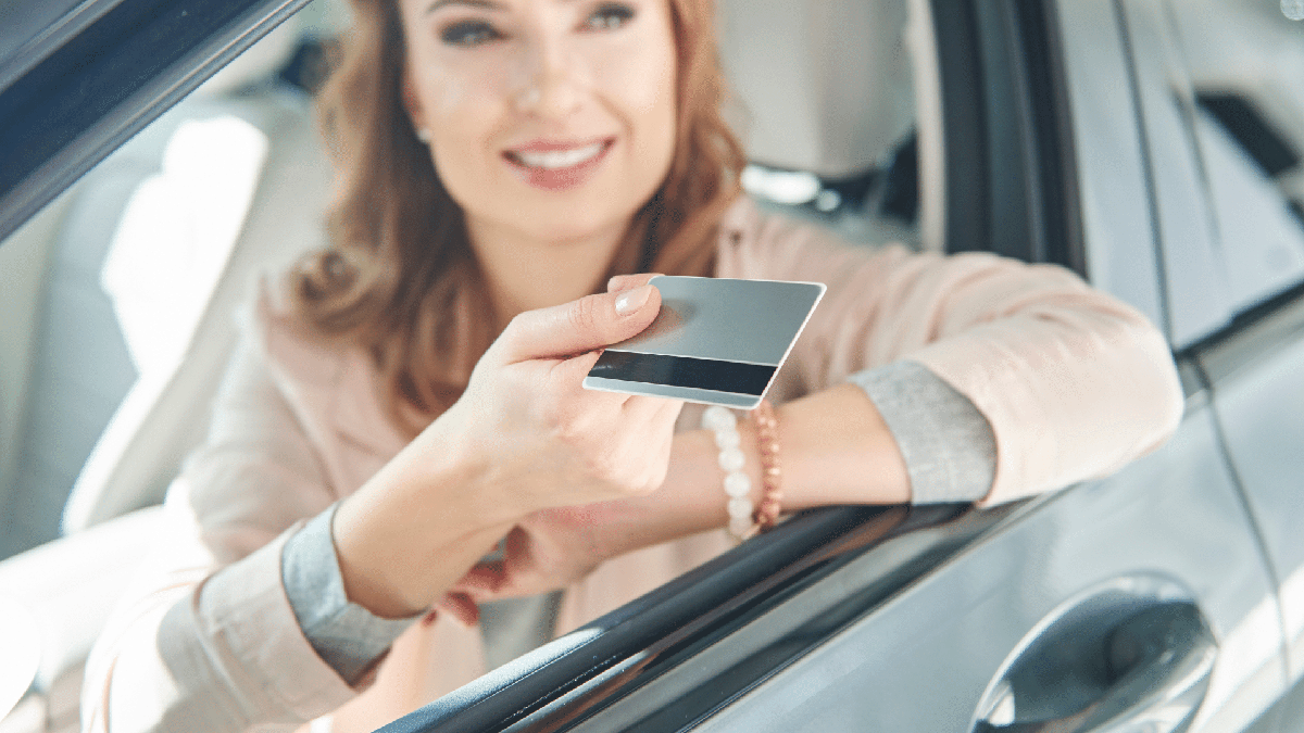 Parcelar Multas: mulher dentro do carro entrega cartão de crédito