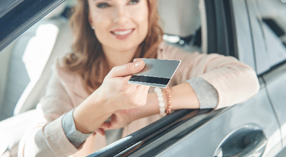 Parcelar Multas: mulher dentro do carro entrega cartão de crédito - Divulgação
