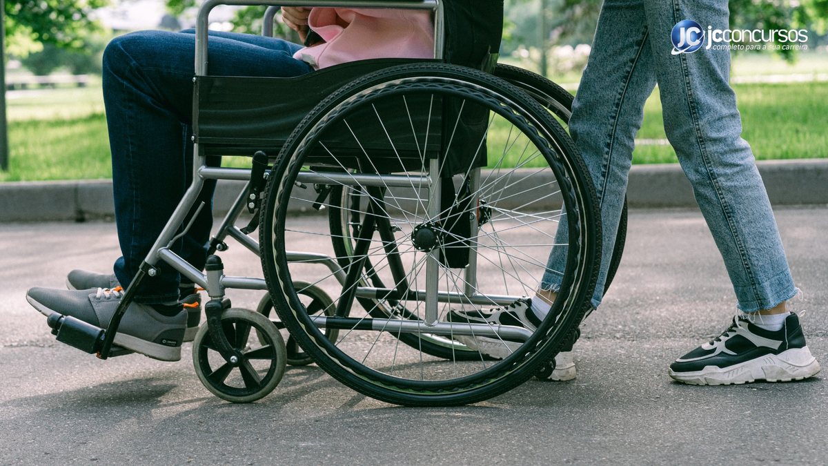Um homem empurra uma cadeira de rodas