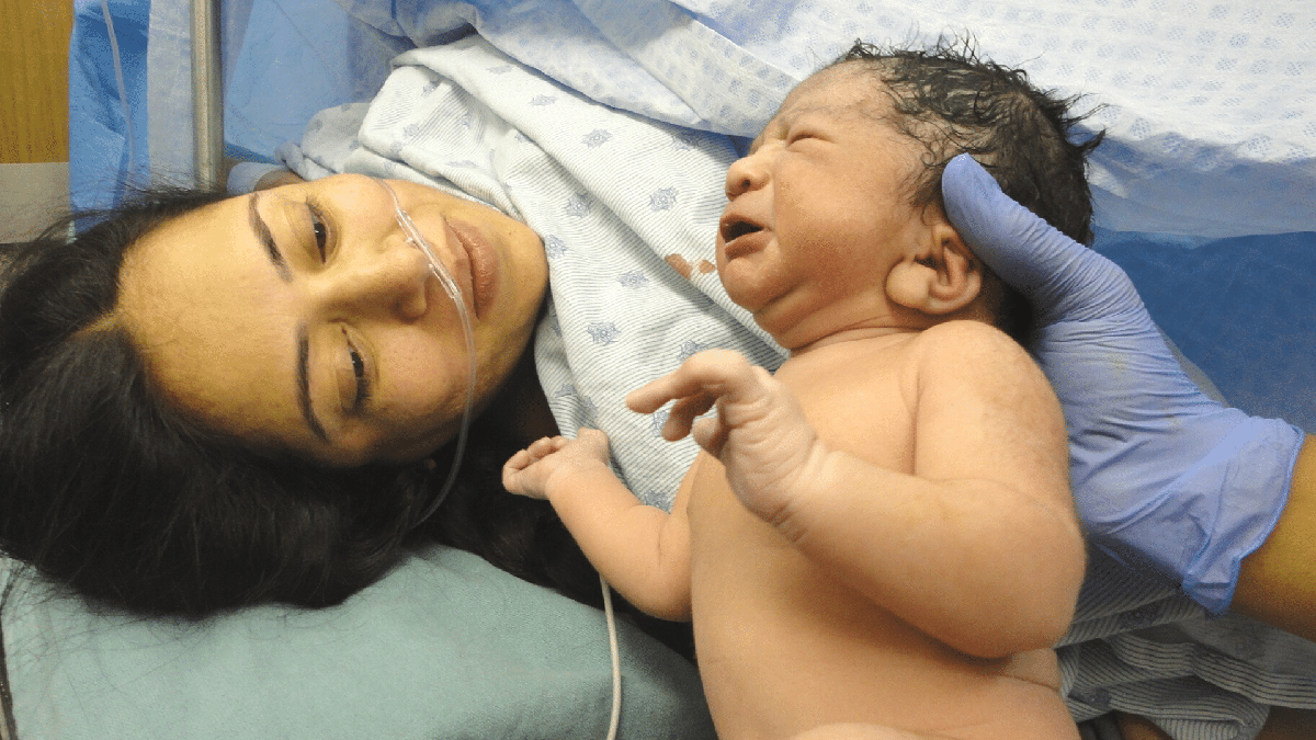 Salário-maternidade: mãe olha bebê após parto