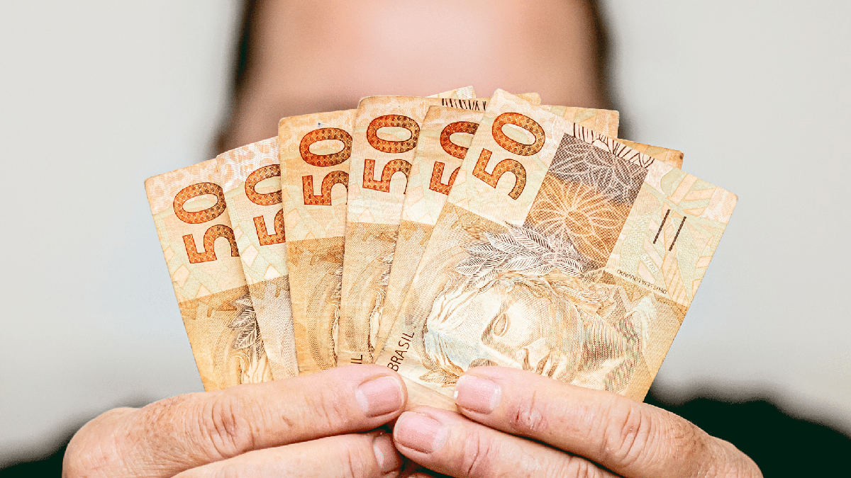 Nota Fiscal Paulista: mulher segura notas de cinquenta reais