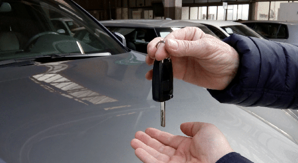 Transferência de veículo online: homem entrega chave de carro a comprador - Divulgação