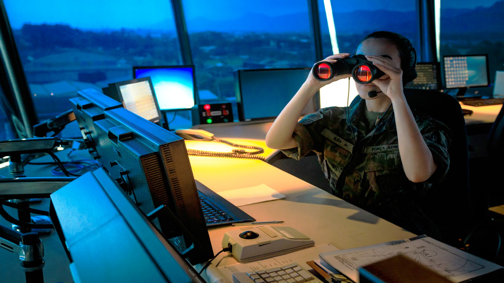 Militar usa binóculo dentro de torre de controle de tráfego aéreo