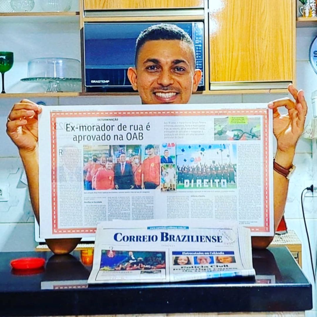 Sérgio segurando um jornal com a reportagem da sua história de vida